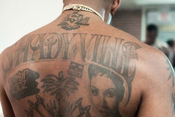 chicano lettering tattoo on the back